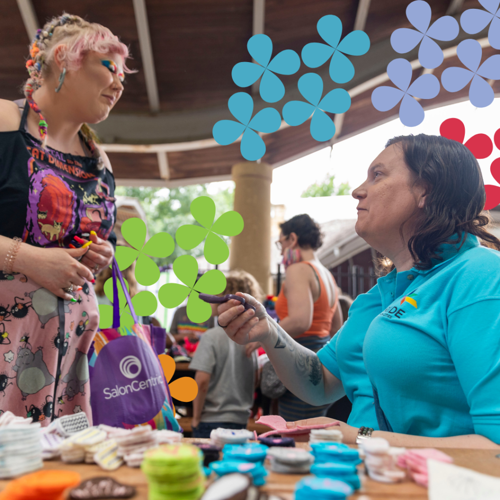 a volunteer talking to an event attendee over a craft table